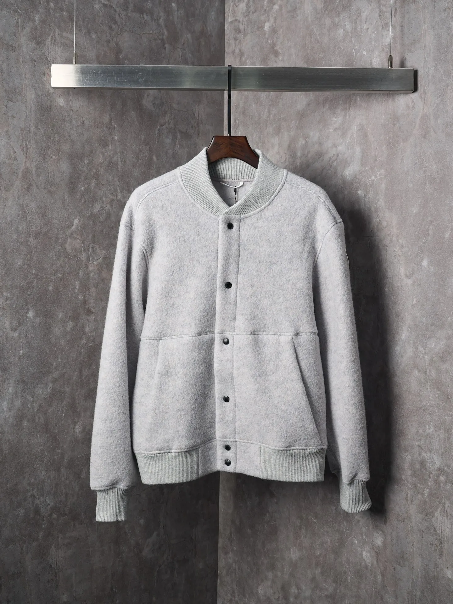 P760 Actual hanging auction] Canada Goose/Canada Goose Fleece Badge Button Cashmere Jacket [Color] Dark Gray Light Gray [Size] S M L XL Wool Blend Fabric: The main fabric of this jacket is light gray wool blend fabric to improve the wear resistance, wrinkle resistance and warmth of the fabric. Wool provides good warmth and a natural feel, while blended fibers enhance the fabric's practicality and durability.  RIBBED KNIT: The collar, cuffs and hem are ribbed knitted for added stretch and fit.  The cutting process needs to ensure that the texture and color of the fabric are evenly distributed, especially with this light gray tone, to avoid chromatic aberrations. The stretchability of wool-blend fabrics needs to be taken into consideration when cutting pieces to ensure dimensional stability of the finished garment.      Use a sewing needle and thread suitable for wool-blend fabrics to avoid damage to the fabric during sewing. The sewing stitches are even and firm to prevent thread stripping.      The temperature needs to be controlled during ironing to avoid high temperature damage to the fabric while keeping the fabric smooth and crisp.   The front and back body parts, sleeves and other main parts are stitched with flat seams to ensure a smooth silhouette.   Align the fabric texture at the splices to keep the look neat.     Details such as pockets and cuffs are designed with inset pockets to increase practicality and aesthetics.     The splicing areas are reinforced to improve durability.  The white circular armband on the left arm is an important part of the brand identity and is finely sewn to ensure it is strong and flat.